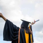 long-haired-female-students-wearing-black-ruffle-dresses-expressing-joy-graduation-university-min